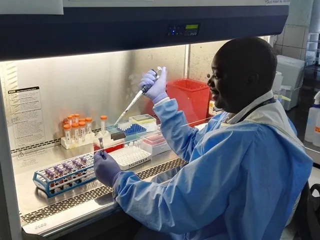 Photo of Dr Munsaka staining blood samples